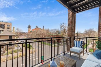 a balcony with a couch and a chair and a view of the city